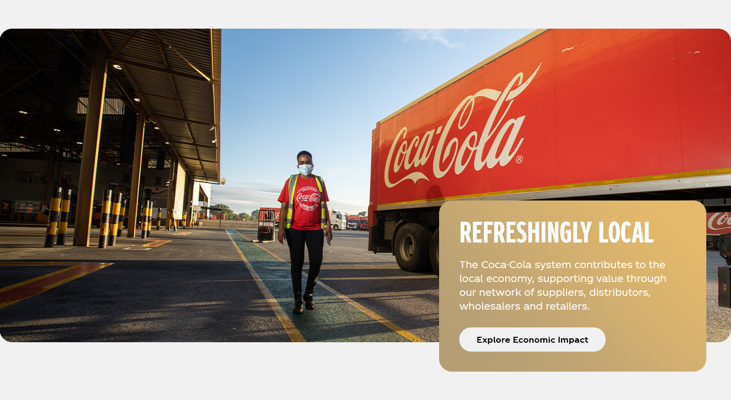 Refreshingly Local: A local delivery drive walks next to a Coca-Cola distribution truck