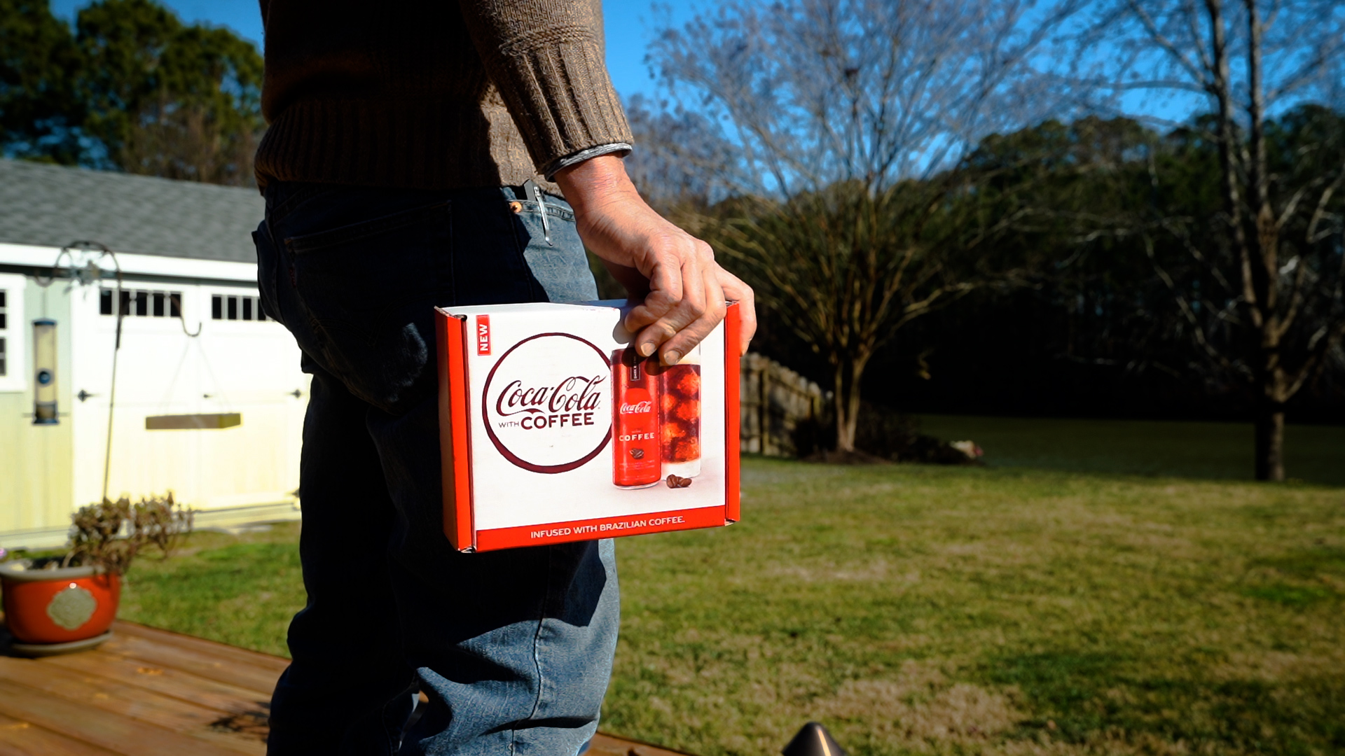 Consumer holding a box of Coca-Cola with Coffee