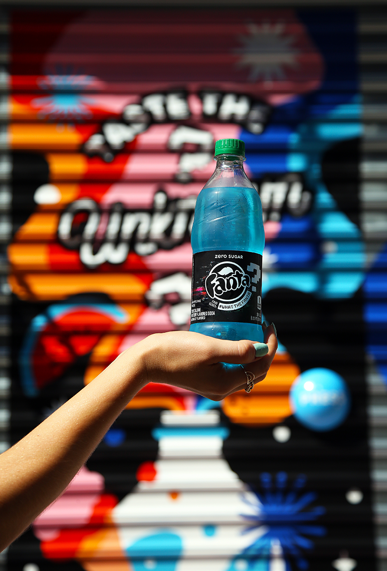 a bottle of blue wtfanta in front of a mural