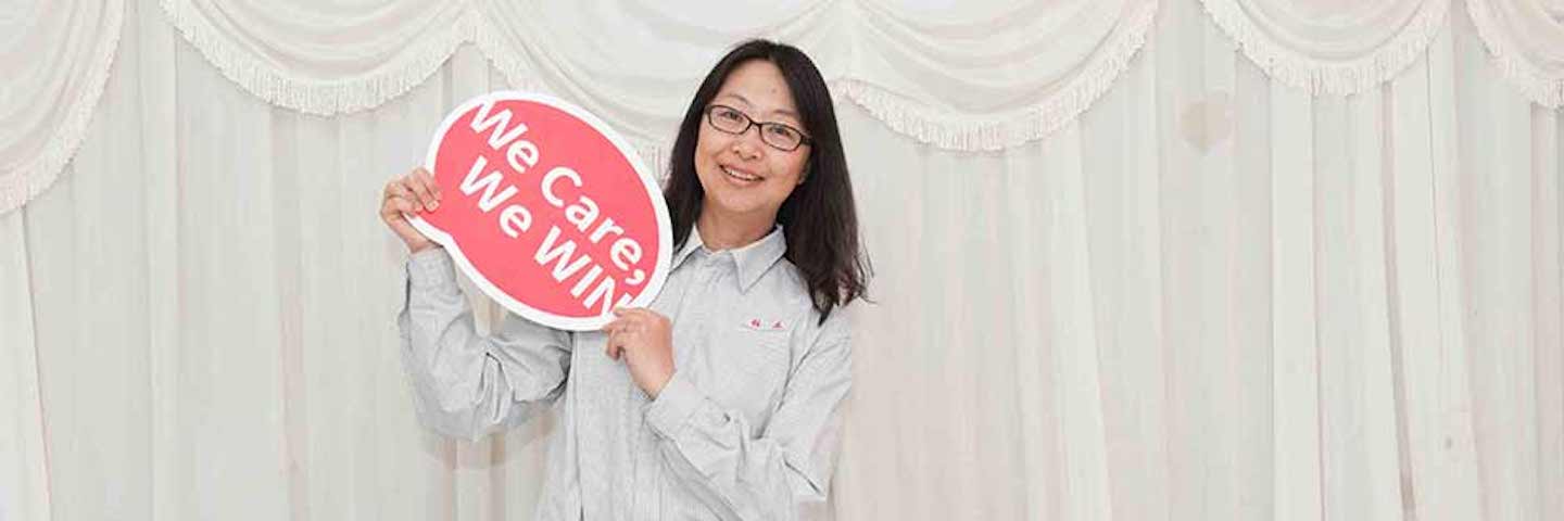 woman holding sign "We care, we win"