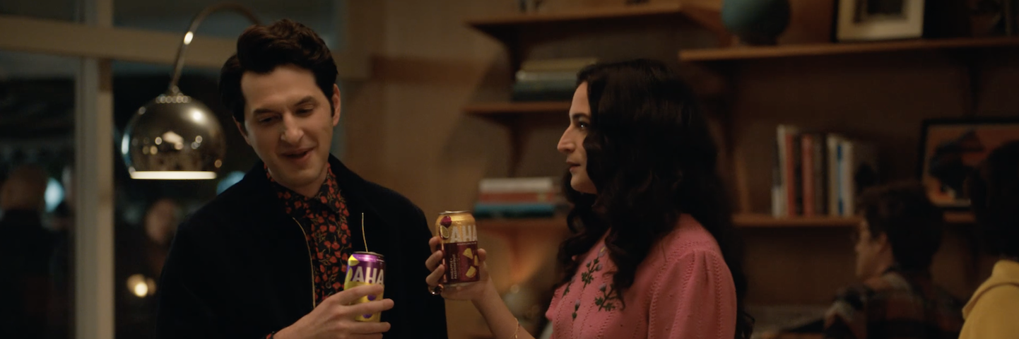 Ben Schwartz and Jenny Slate drink AHA at house party. Ben Schwartz and Jenny Slate drink AHA at a party.
