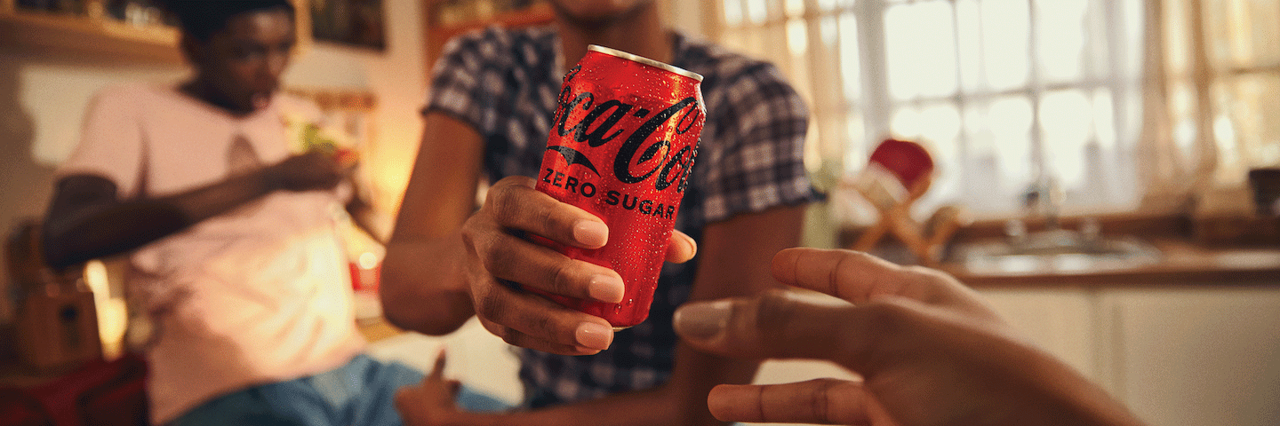 Girl handing a Coca-Cola Zero Sugar can to someone Girl handing someone a can of Coca-Cola Zero Sugar