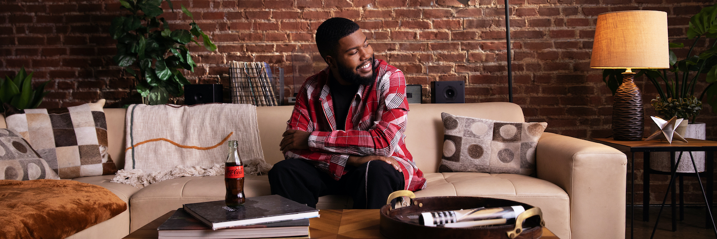 Khalid poses with glass bottle of Coca-Cola Zero Sugar