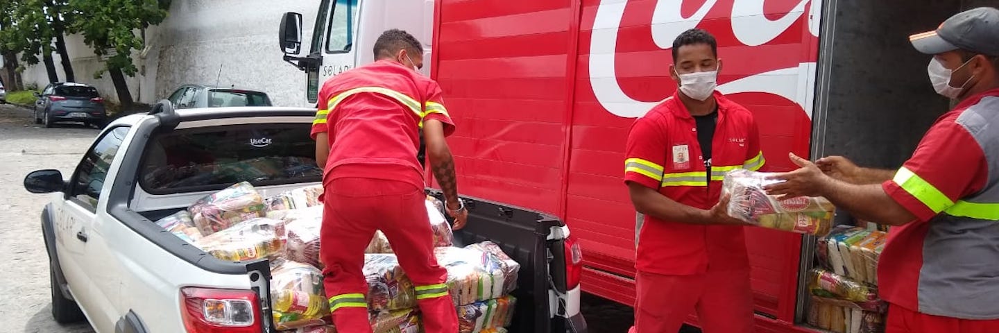 Coca-Cola workers loading a truck with food for COVID-19 relief Coca-Cola workers loading a truck with food for COVID-19 relief