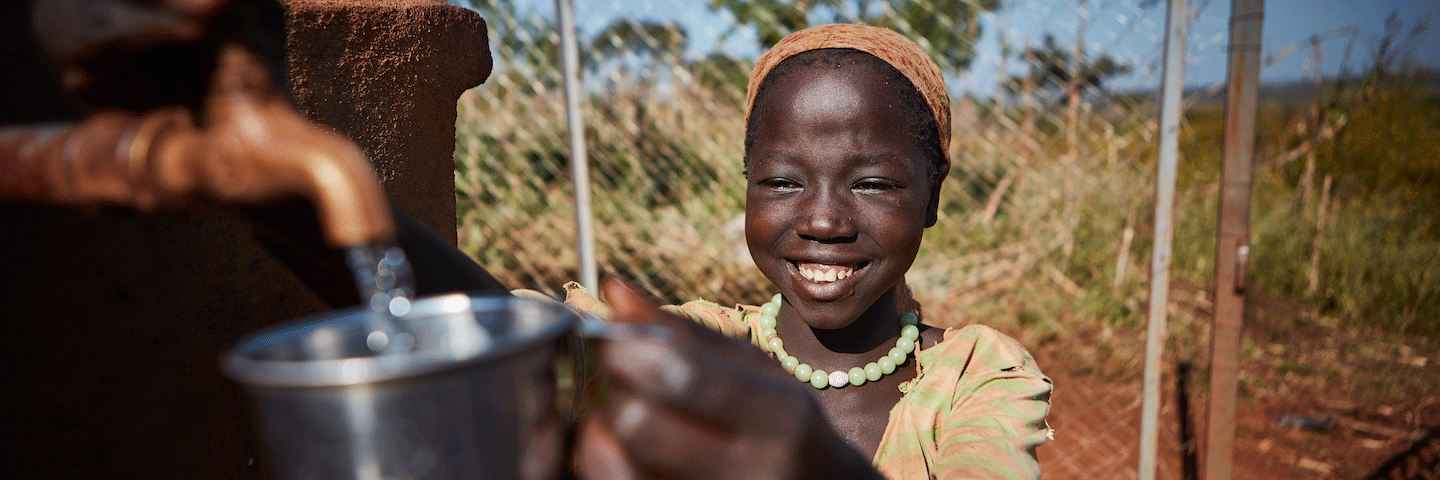 Young Ethiopian woman receives fresh water in a canteen