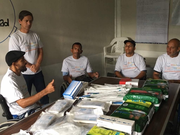 A group of men with spinal cord injuries in Venezuela receive a shipment of medical supplies from Wheels of Happiness.