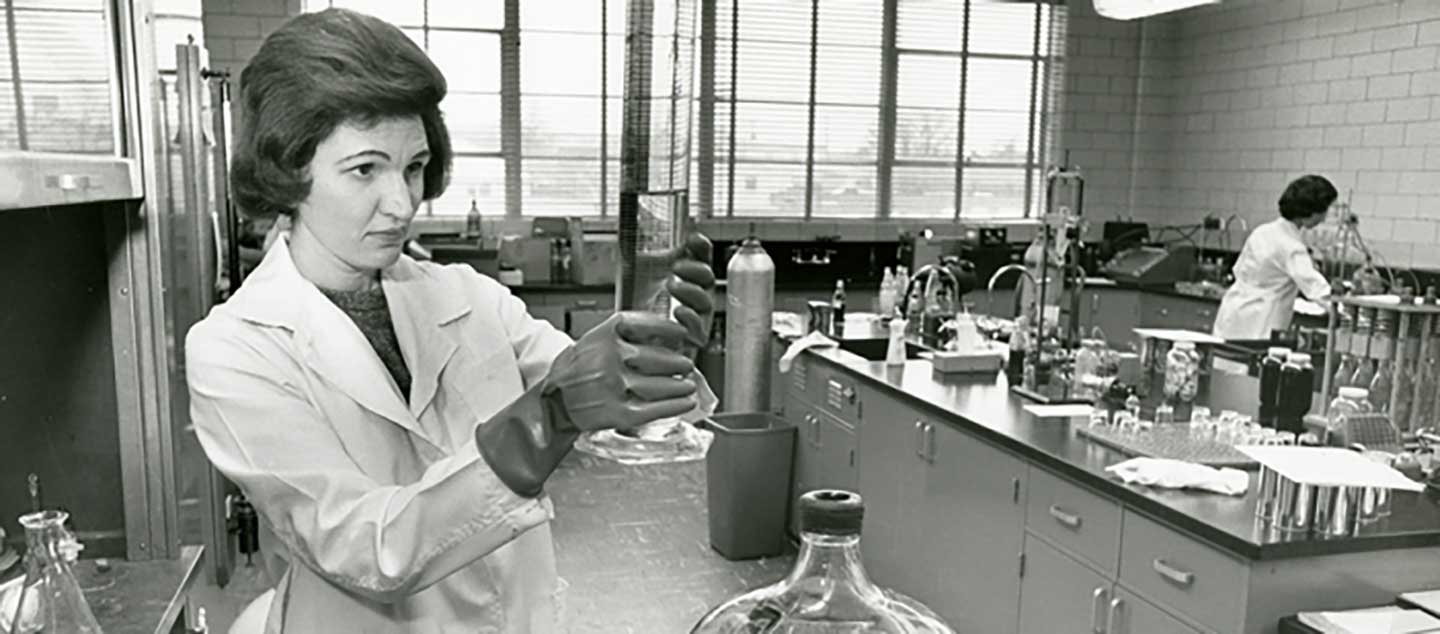 Black and white photo of woman working in Coca-Cola laboratory.