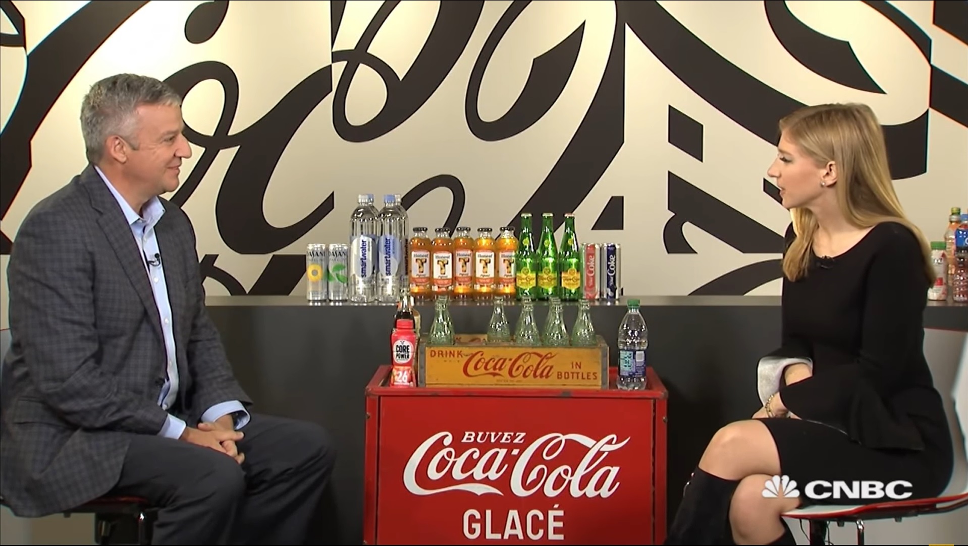 Man and woman chatting over vintage Coca-Cola product box