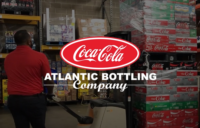 Coca Cola Atlantic Bottling Company Logo with warehouse in background