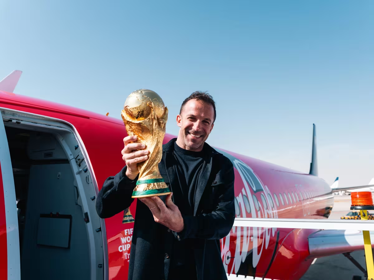 Man holding trophy in front of plane