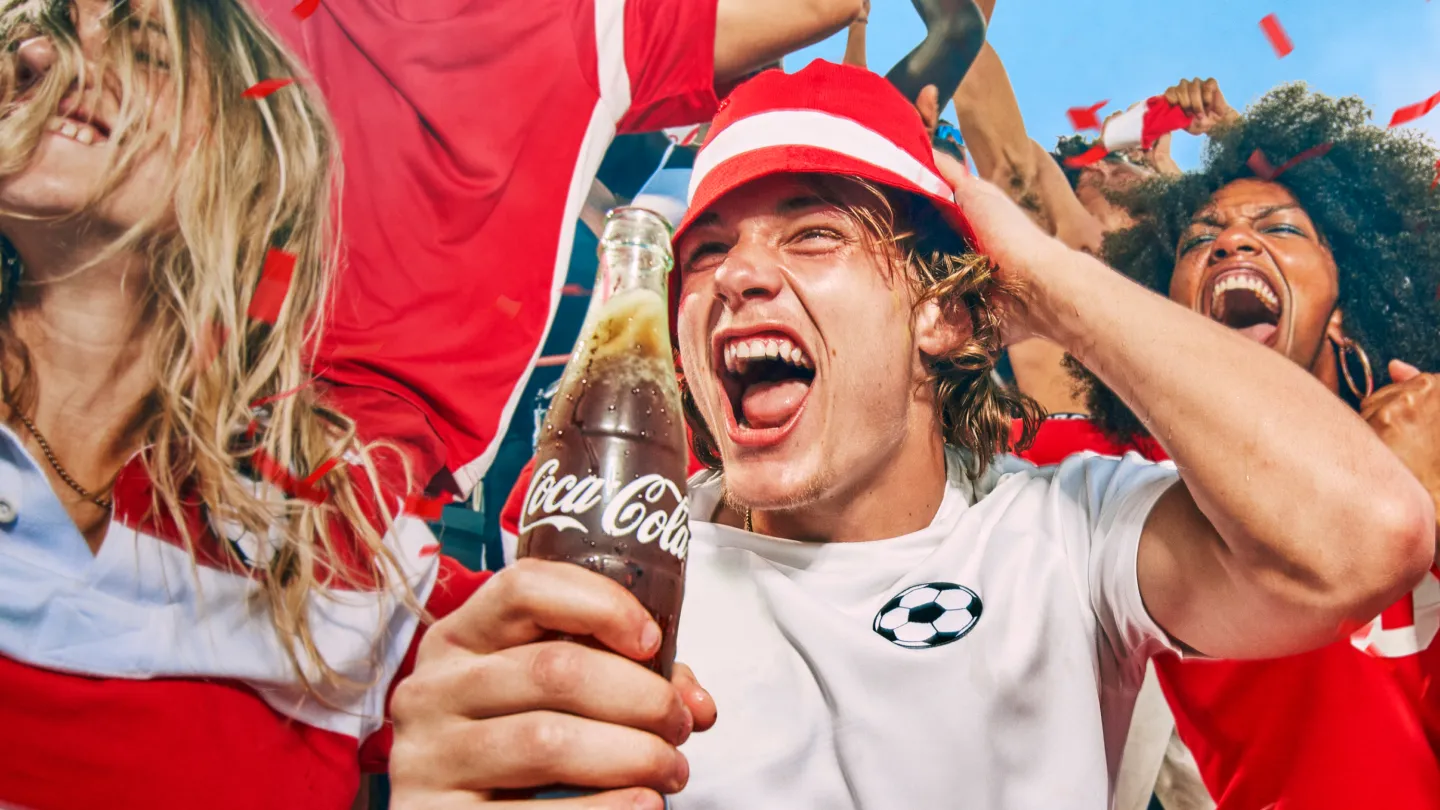 FIFA fans cheering at game holding Coca-Cola