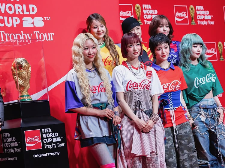 A group of girls standing by the trophy
