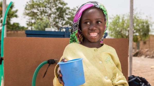 A happy kid with a cup of water