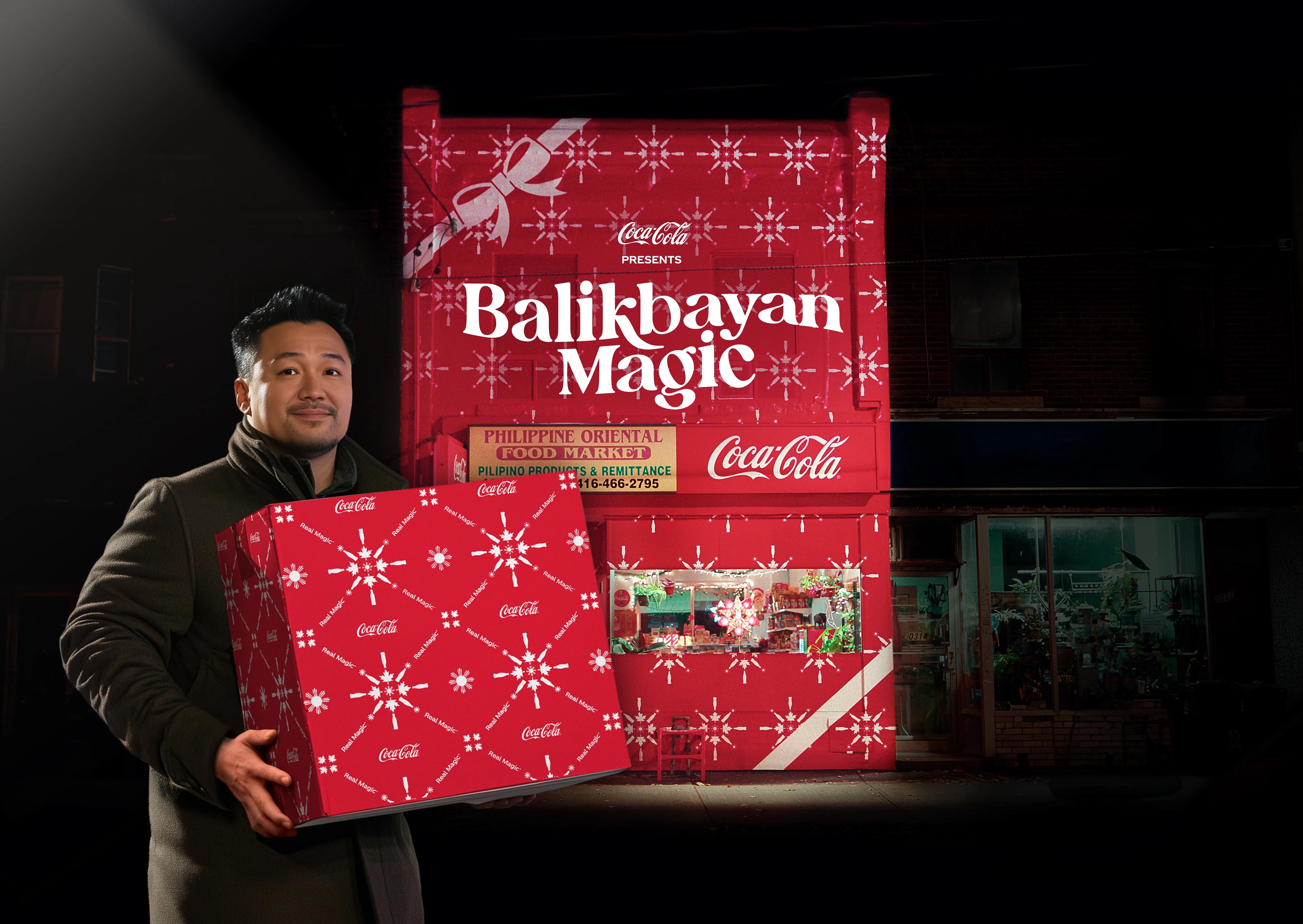 Man holding a gift box in Coca-Cola branded wrapping standing outside of a store also covered in Coca-Cola wrapping paper