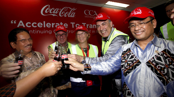 A bunch of people having a drink of coca-cola