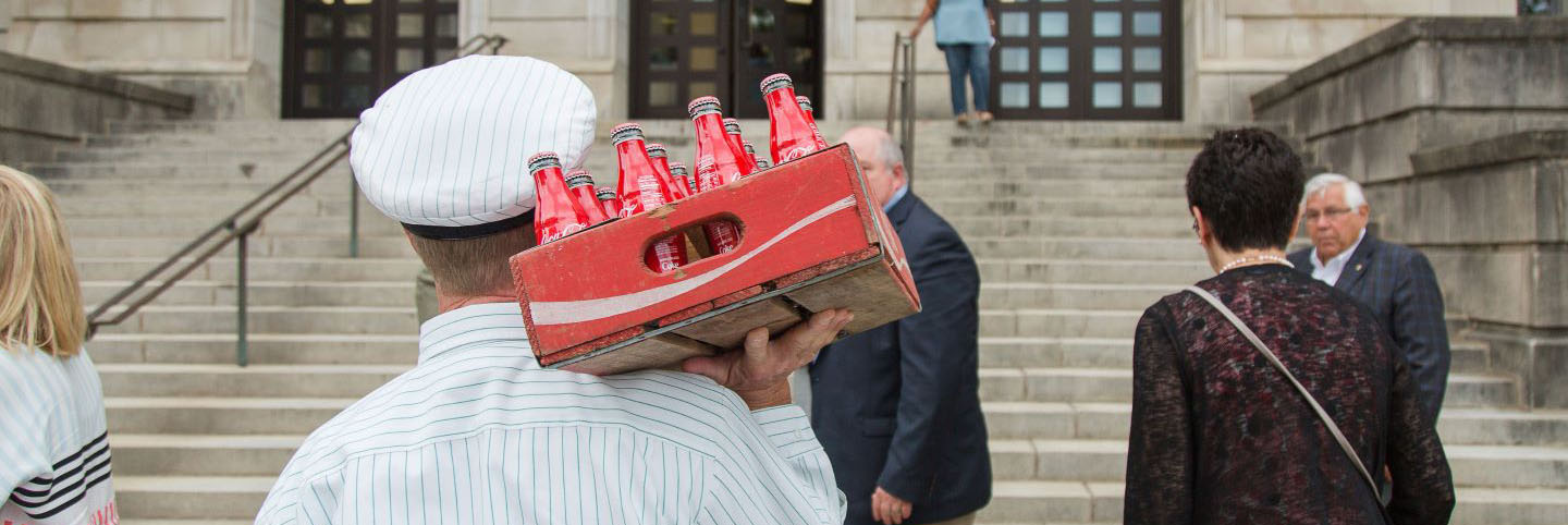 Man holding a crate of Coca-Cola bottles
