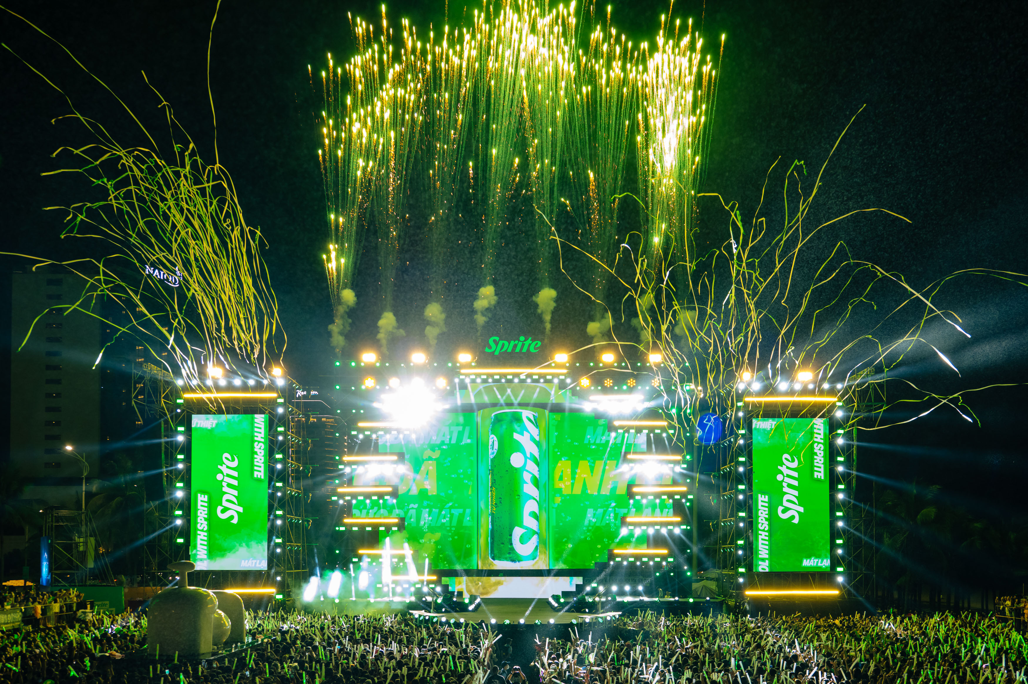 A stage with screens showing Sprite images while fireworks are going off