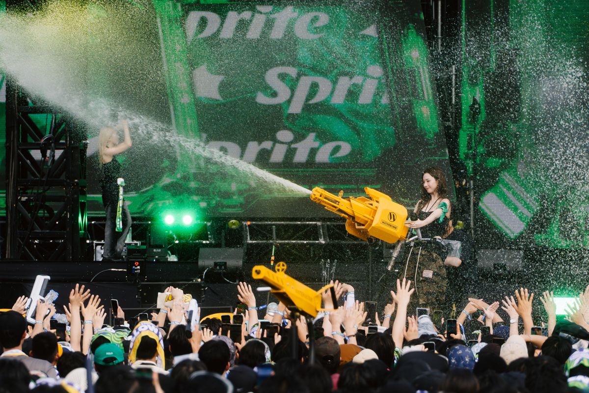 Performers spraying large water guns on a stage