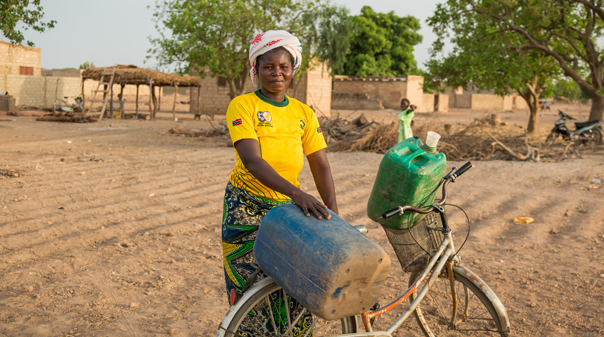 Woman carrying water on a bicylce