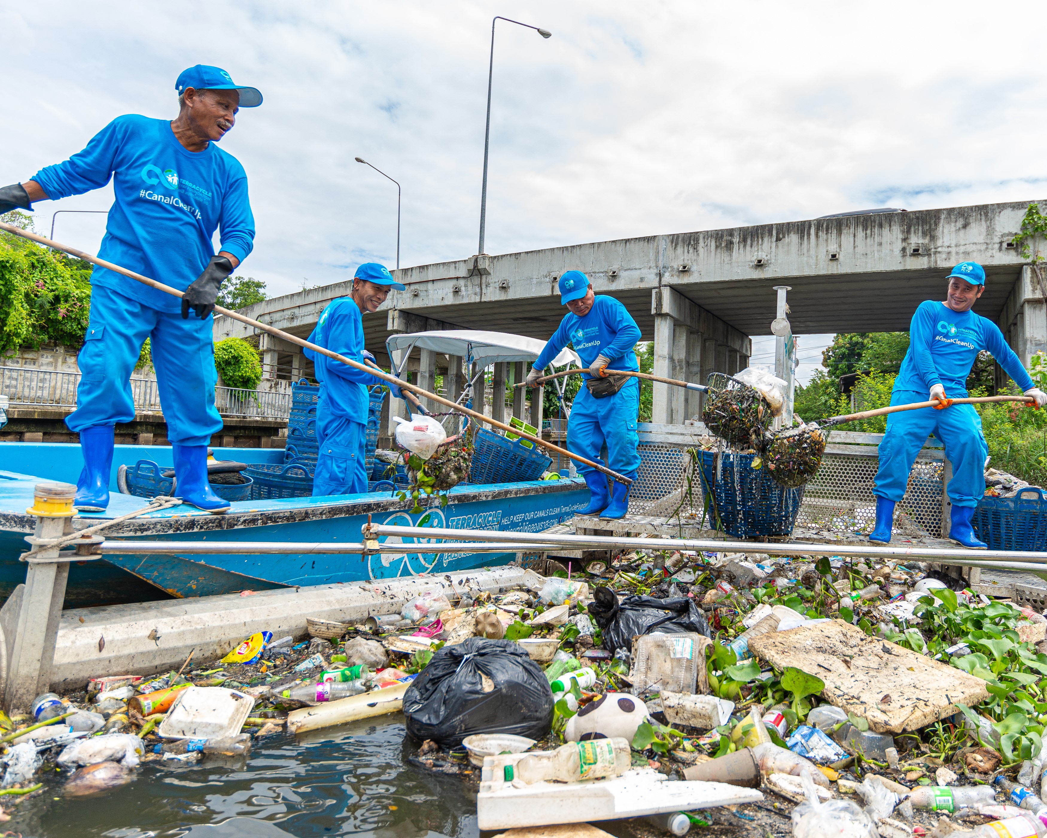 Clean Currents Coalition members cleaning water near a bridge