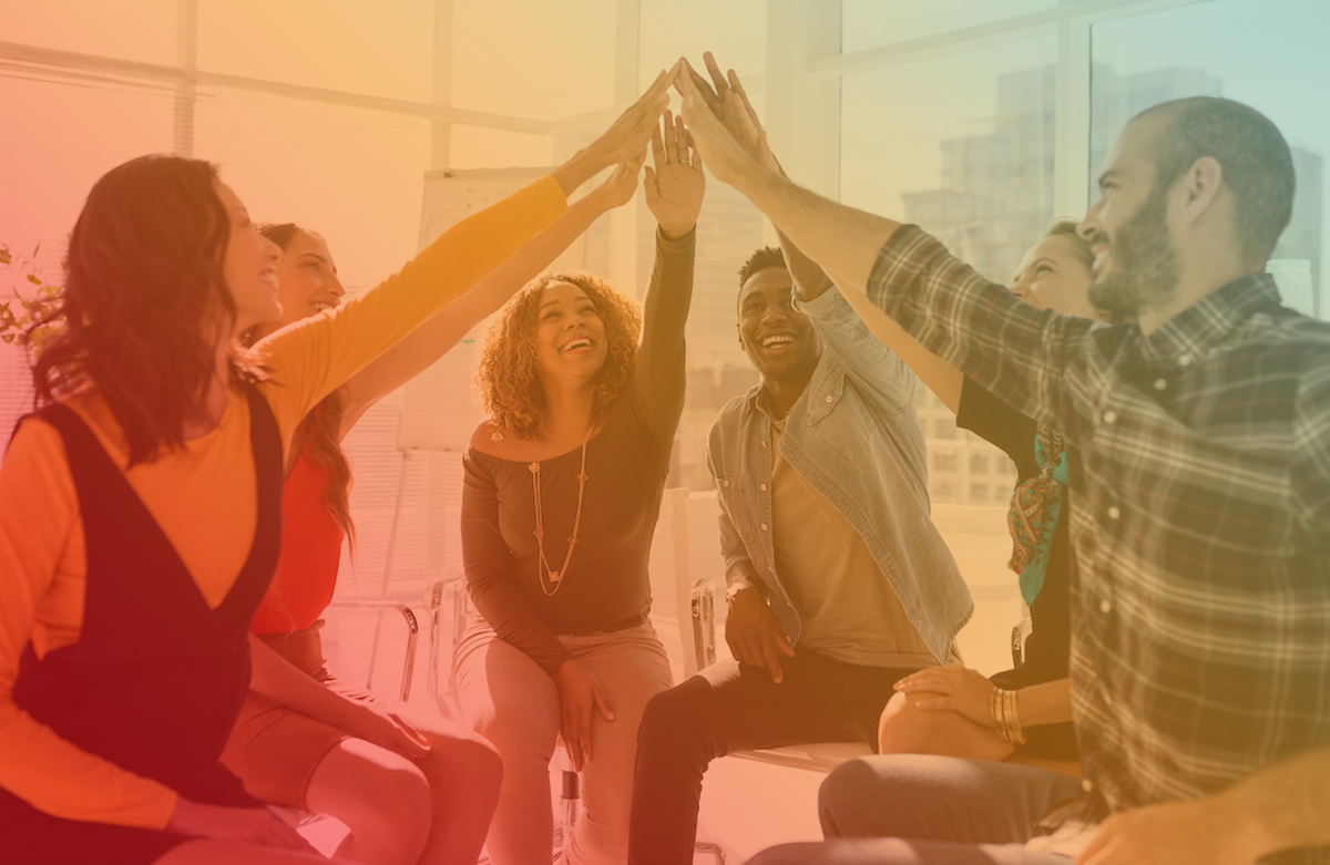 Diverse group of corporate executives talking together around a table during a meeting in a bright modern office