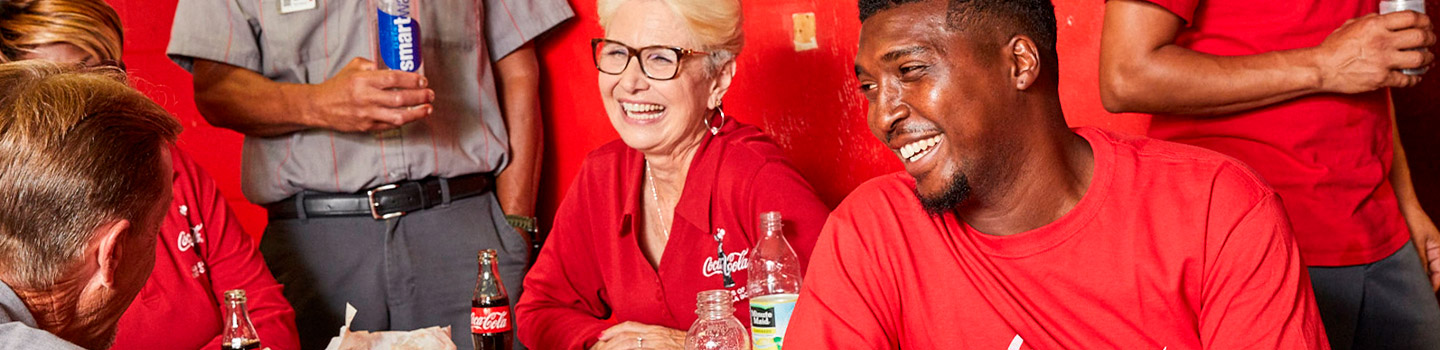 Employees laughing and drinking Coca-Cola brands