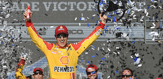 Celebrating victory at Nascar while holding a Coca-Cola Classic in one hand and a steering wheel in the other