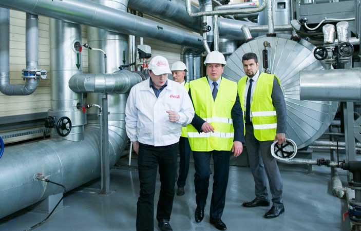 Coca-Cola factory employee leading tour of bottling plant