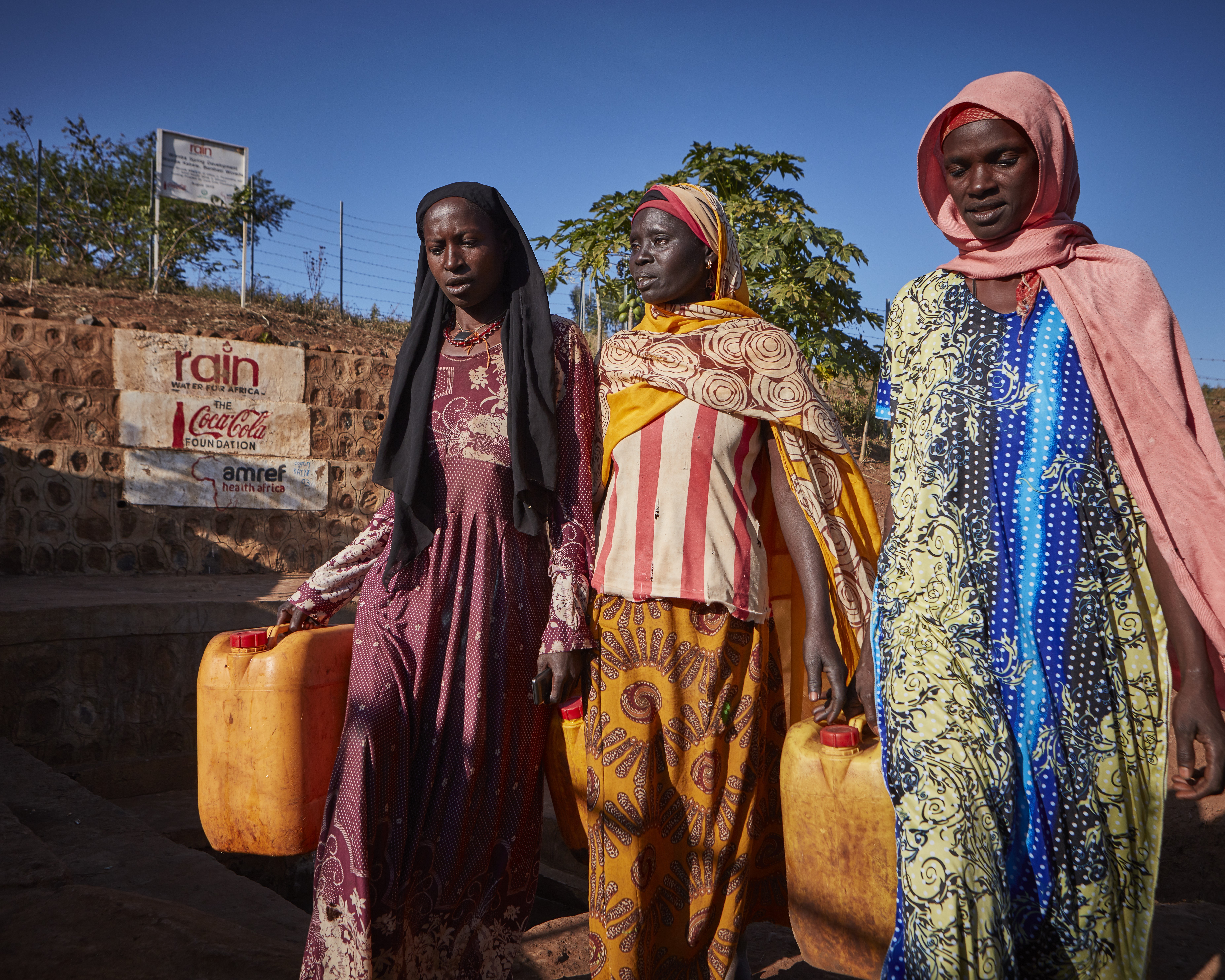 Three African women carrying clean water