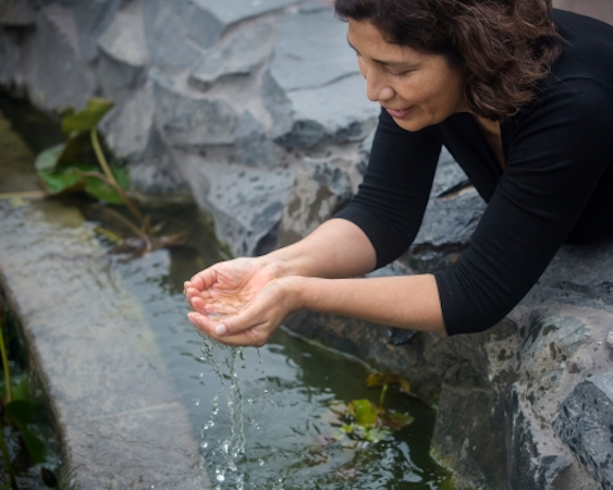 A women cupping clean water with her hands