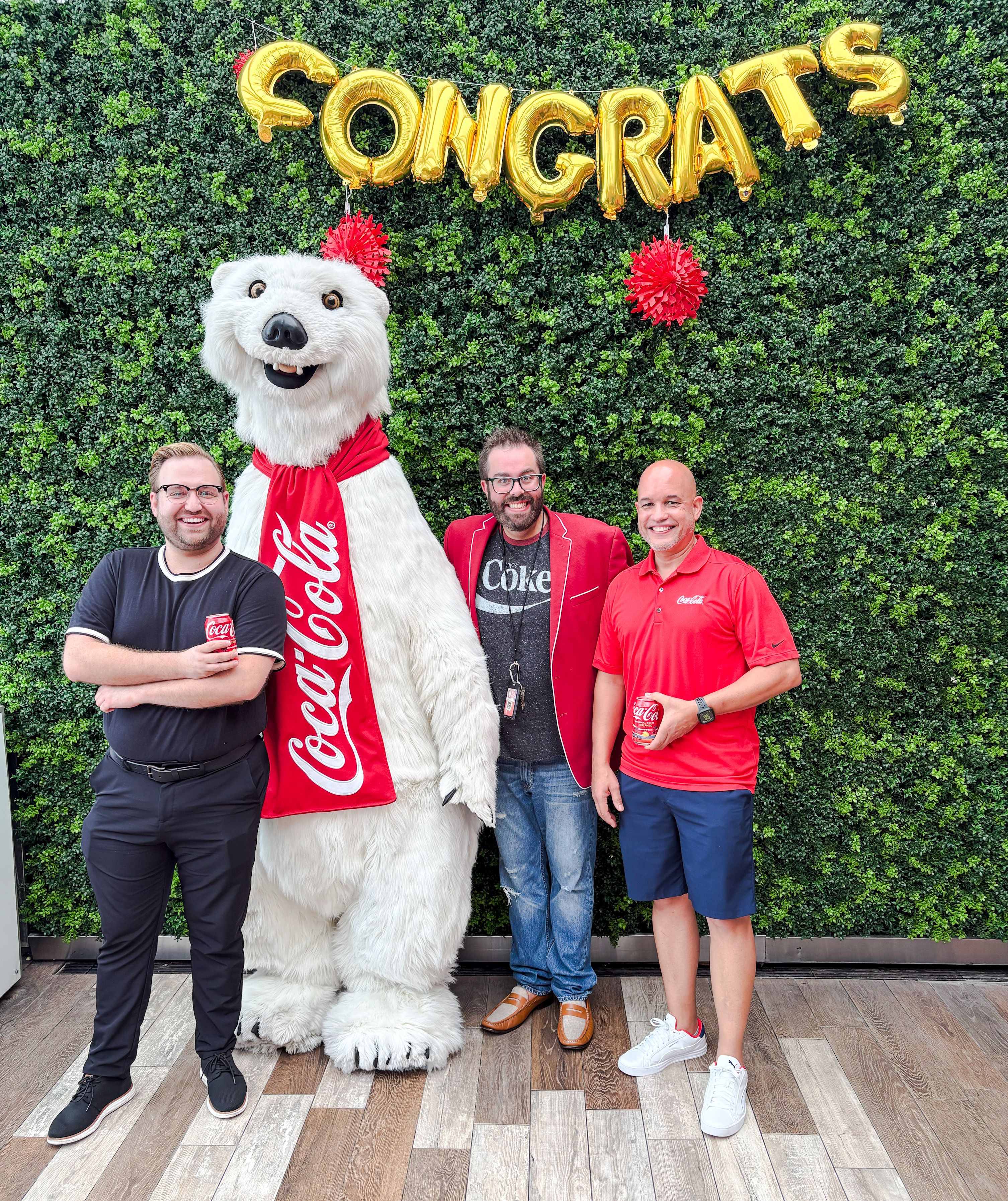 3 Coca-Cola team members pose with the iconic Coca-Cola Polar Bear for the 10-year celebration