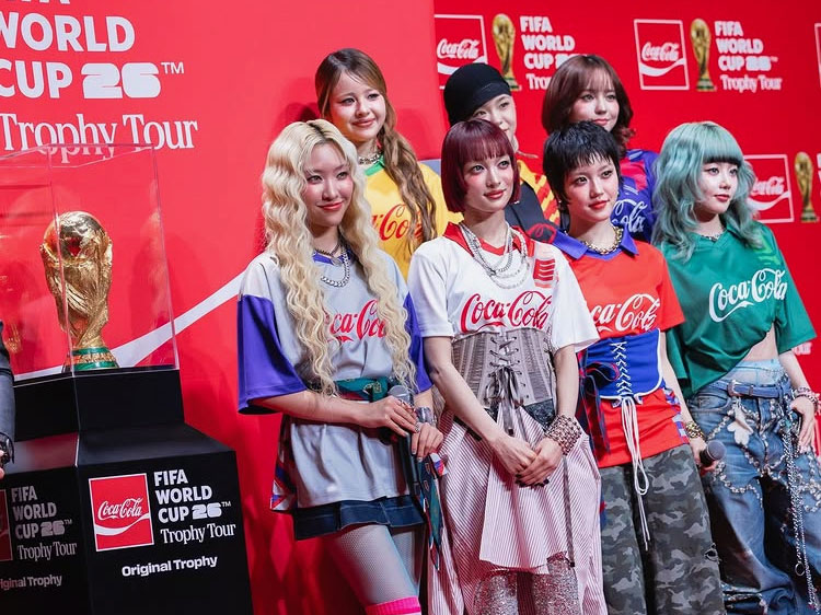 A group of girls standing by the trophy