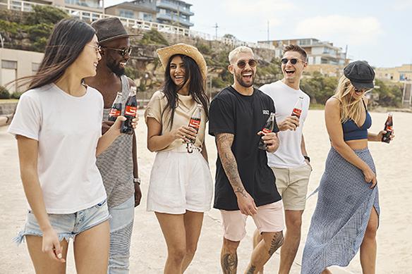 Share a Coke with everyone this summer A group of friends enjoying Coca-Cola whilst strolling.