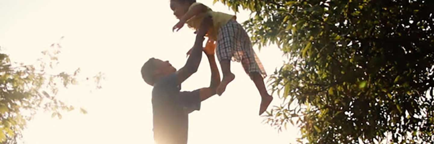 Man lifts child into the air