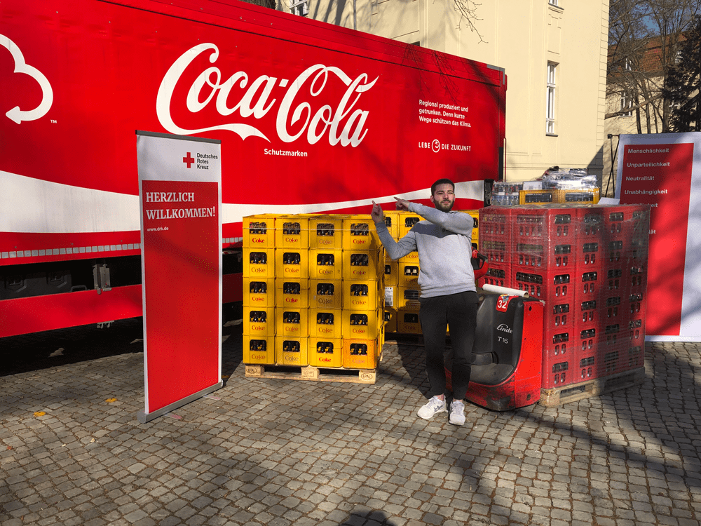 A Coca-Cola associate presents a product donation to the German Red Cross.