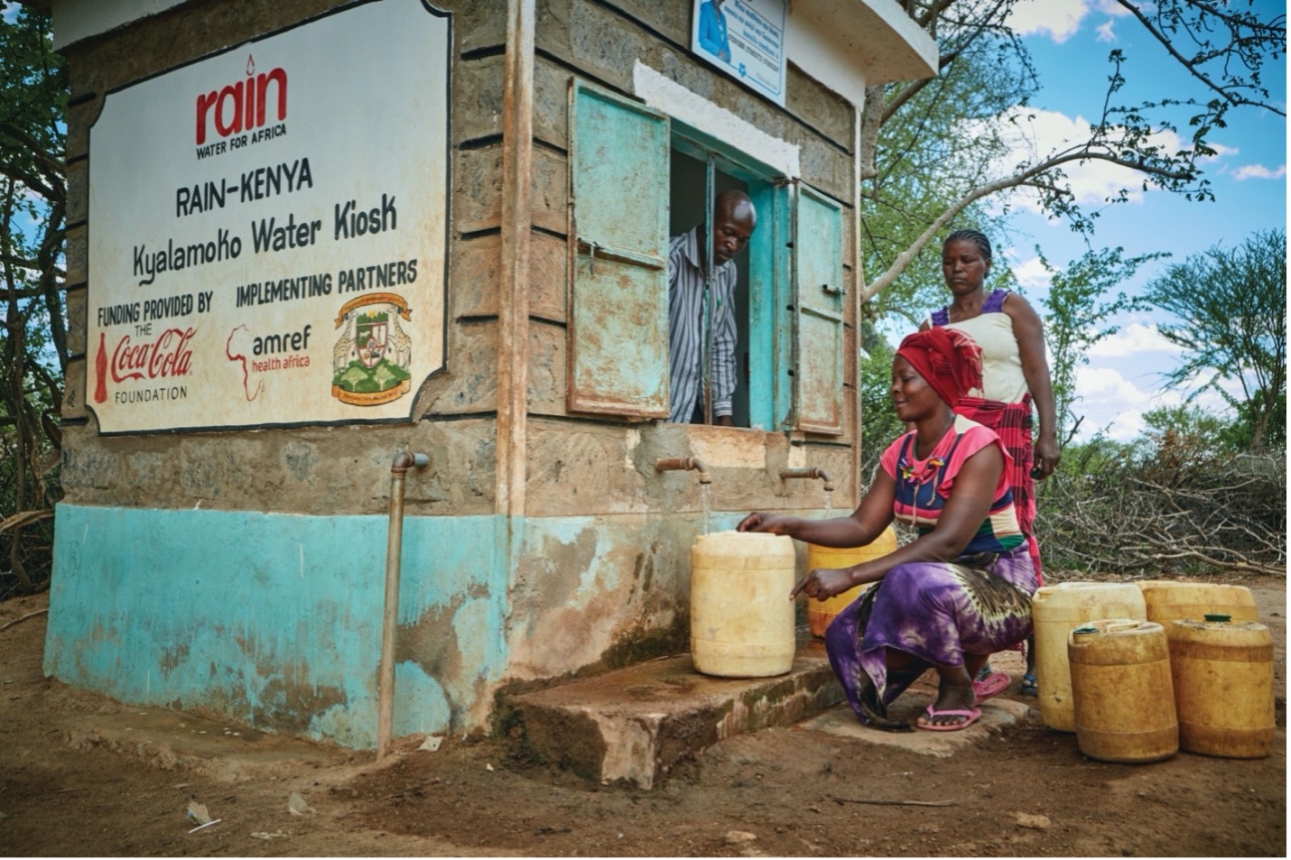 Woman filling a bucket with water at a RAIN Kenya water kiosk